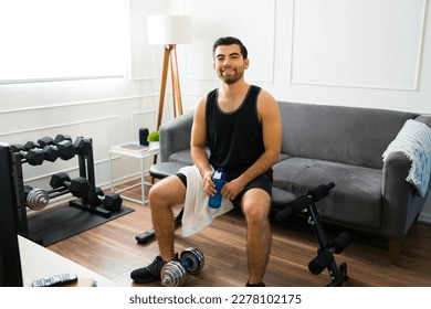 Portrait of an attractive young man smiling while looking cheerful after working out in the living room - Shutterstock ID 2278102175