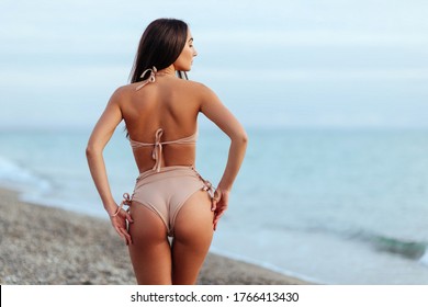 Portrait Of Attractive Young Woman In Bikini On The Beach. Young Caucasian Female Model Posing In Swimsuit On The Sea Shore And Smiling.