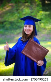 Portrait Of Attractive Young Woman In Cap And Gown After Graduation In 2020