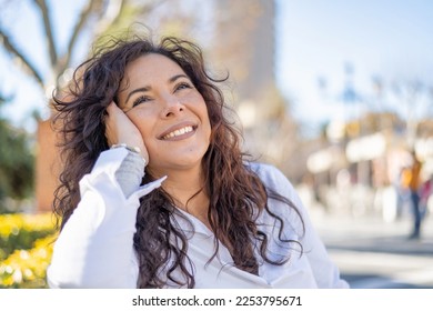 Portrait Of An Attractive Young Woman Smiling. Happy Woman Enjoying A Spring Day In A City Park. - Shutterstock ID 2253795671
