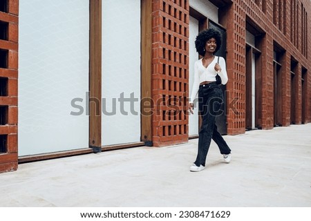 Portrait of attractive young woman walking outside in the city