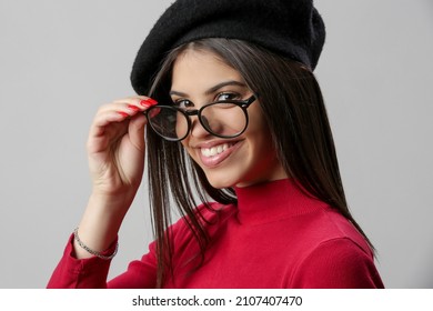 Portrait Of Attractive Young Woman Wearing Reading Glasses And Black Beret.