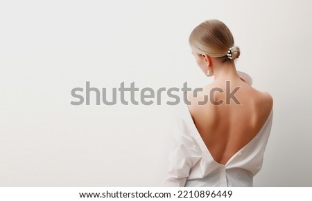 portrait of attractive young woman in white blouse, slick hair, fashion trend, simple apparel, natural look, casual style, isolated on studio background