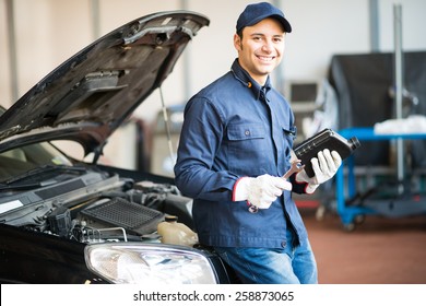 Portrait of an auto mechanic holding a jug of motor oil - Powered by Shutterstock