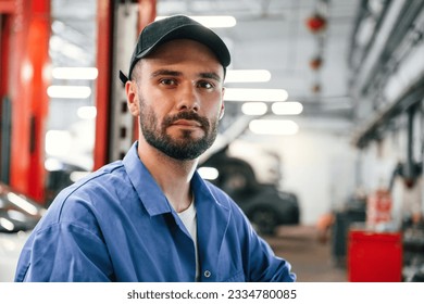 Portrait of auto mechanic that is in garage. Repair service. - Powered by Shutterstock