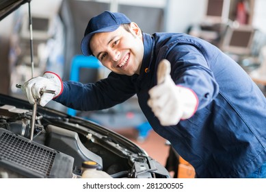 Portrait of an auto mechanic at work on a car in his garage