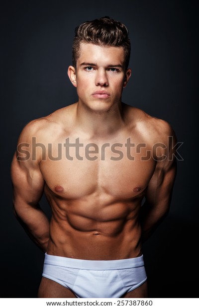 Portrait Of Awesome Male Model With Naked Muscular Body Isolated On Dark Grey Background
