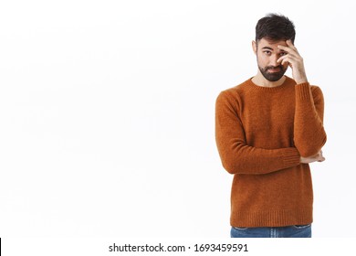 Portrait Of Awkward And Embarrassed Bearded Man Pretend He Not See His Ex, Hiding Face Behind Hand, Facepalm And Peek Through Fingers, Avoiding Eye Contact, Standing White Background