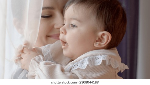 Portrait of a baby in the arms of mother. The mental peace of the child is safe. Maternal attachment of personality in education. Short hair.