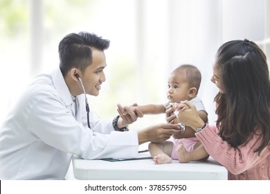 portrait of a baby being checked by a doctor using a stethoscope