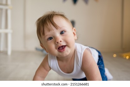 Portrait Of A Baby Boy With A Squint Crawling On The Floor In The Nursery