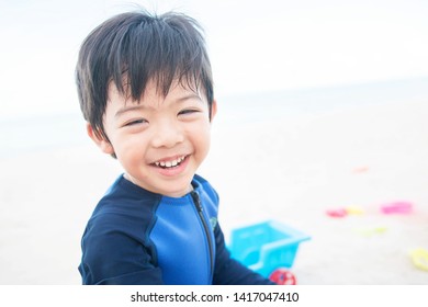 Portrait baby cute boy playing in the sandy beach, happy and Smiling child.