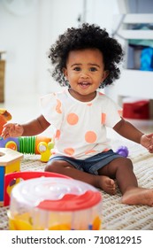 Portrait Of Baby Girl Having Fun In Playroom With Toys
