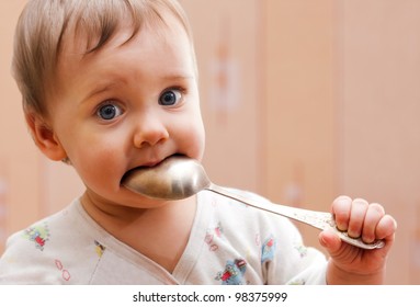 Portrait Of Baby Girl Holding Spoon In Mouth