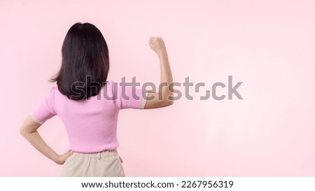 Portrait back of woman proud and confident showing strong muscle strength arms flexed posing, feels about her success achievement. Women empowerment, equality, strength and courage concept