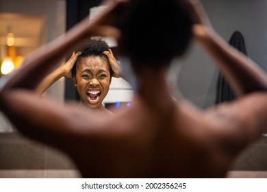 Portrait from back of young african american woman adjusting hair in mirror and shouting - Powered by Shutterstock