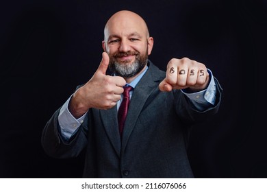 Portrait Of A Bald Business Man In Suit On Dark Background. Smile On The Face, Thumbs Up And Sign Boss On His Fist. The Model Is In His 40s, Grey And Dark Hair Beard. Good Boss Concept