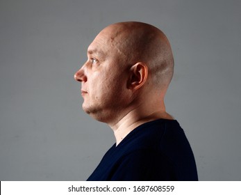 Portrait of a bald cheerful man in profile on a black background