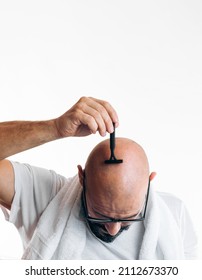 Portrait Of Bald Man Looking Down Showing Head And A Shaver. 