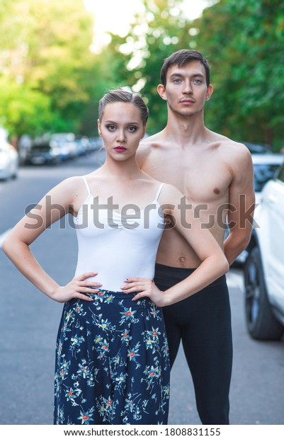 Portrait of a\
ballet couple on the street among\
cars