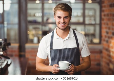 Portrait Of A Barista Holding A Cup Of Coffee At The Coffee Shop