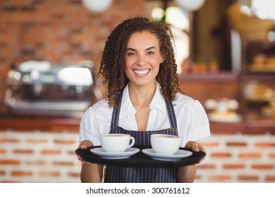 Portrait Of Barista Holding A Tray Of Coffee Cups At The Coffee Shop