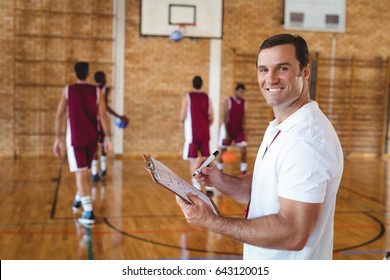 Portrait Of Basketball Coach Holding Clipboard In The Court