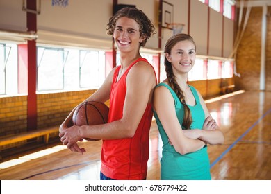 Portrait Of Basketball Players Standing Back To Back In Court