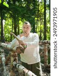 Portrait of a bearded axeman working in a sunlit woodland. The peaceful environment and rich timber background emphasize the cultural heritage and artisanal skills of forestry