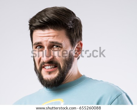 Portrait of bearded guy with disgusted expression on face