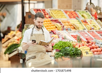 Portrait of bearded man calling supplier while selling fresh fruits and vegetables at farmers market, copy space