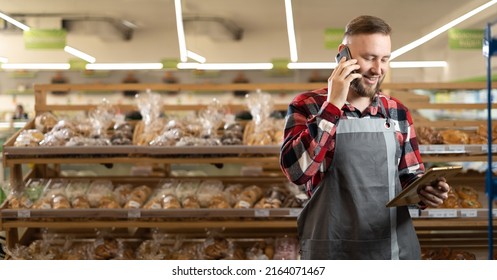 Portrait of bearded man calling supplier while selling fresh bread and grocery at supermarket, banner, place for text - Powered by Shutterstock