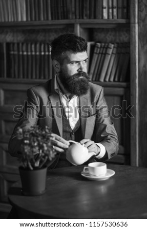 Portrait of bearded man drinking tea in vintage library