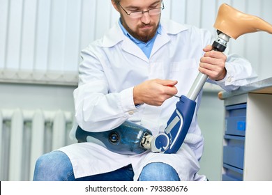 Portrait Of Bearded Technician Checking Artificial Limb While Sitting At Desk In Office, Adjusting It And Checking For Quality