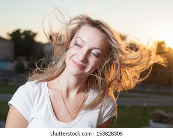 Portrait of a beautiful 20s young woman at sunset. Close-up, hairs and wind  - Shutterstock ID 153828305