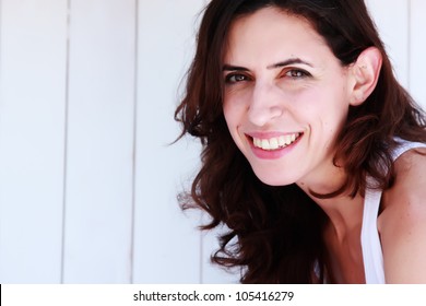 portrait of a beautiful 35 year old girl on a background of vintage white fence