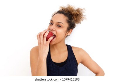 Portrait of beautiful african american girl eating apple against white background