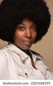portrait of beautiful african american woman in her 20s with afro hairstyle posing confidently on neutral background Stock Photo