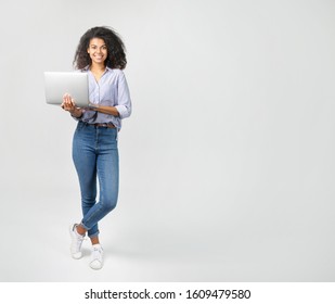 Portrait einer schönen afrikanischen Frau mit Laptop auf grauem Hintergrund