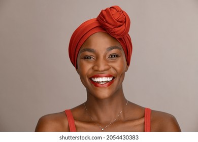 Portrait of beautiful african woman with red headscarf against brown background with copy space. Cheerful black mid woman wearing ethnicity headband. Mature happy lady with traditional clothes. - Powered by Shutterstock