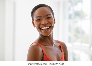 Portrait of beautiful african woman smiling and looking at camera. Portrait of middle aged black woman with a big grin. Carefree and cheerful lady smiling at home in the morning. - Powered by Shutterstock