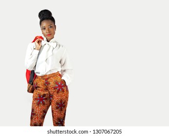 Portrait of a beautiful African woman wearing an African print pant suit holding her jacket with her hand in her pocket