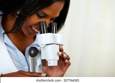 Portrait Of A Beautiful Afro-american Black Woman Using A Microscope At Soft Colors Composition