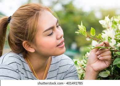 Portrait Of Beautiful Asia Young Long-haired And Invisalign Woman In Park And Smelling Flowers. Concept Eart Day, Save Eart. 