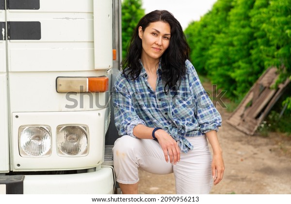 Portrait of beautiful asian brunette next to a\
truck cabin