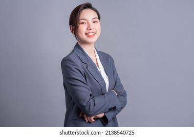 Portrait of a beautiful Asian businesswoman on a gray background
 - Shutterstock ID 2138540725