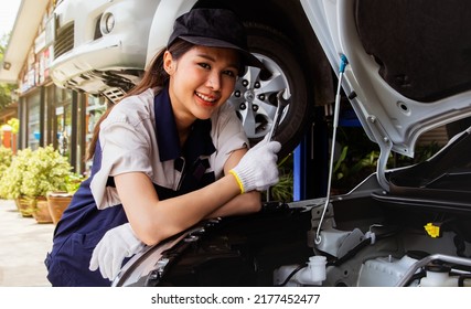 Portrait Beautiful Asian Female Mechanic Engineer Holding Maintenance Wrench Inspects Car In A Workshop Working In The Field, Specializing In Modern Car Internal Combustion Engines.