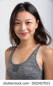 Portrait Beautiful Asian Girl With Big Smile And Brown Hair. Sportswear And Lipstick. White Background