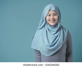 Portrait of beautiful Asian muslim woman wearing blue hijab smiling at camera