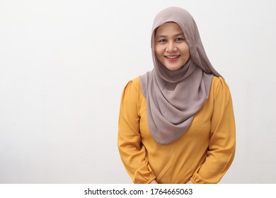 Portrait of beautiful Asian muslim woman wearing hijab smiling at camera, isolated on white